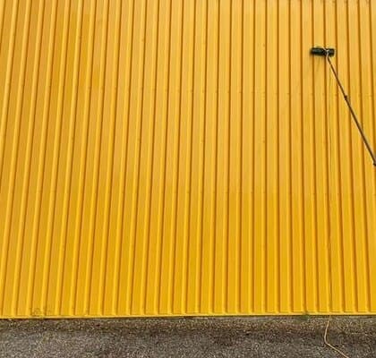 Bardage métallique jaune ravivé après nettoyage professionnel